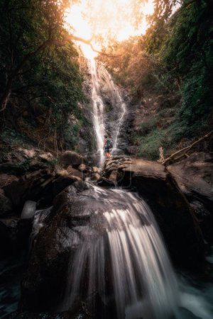 Photo for A male hiker standing in the middle of a waterfall in Sai kung, Hong Kong, China - Royalty Free Image