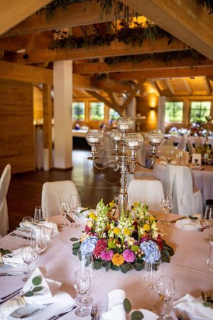 Téléchargez les photos : Plan vertical d'un restaurant avec une table décorée de fleurs pour une occasion de mariage - en image libre de droit