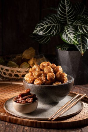 Photo for Hot bowl of freshly cooked orange chicken of thai or chinese food accompanied by bbq pork and chopsticks - Royalty Free Image