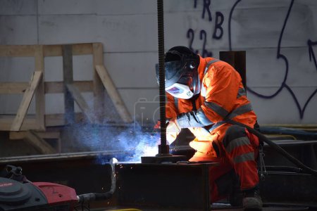 Téléchargez les photos : Un homme en costume de travail et avec un casque, soudure sur le chantier du métro de Vienne - en image libre de droit