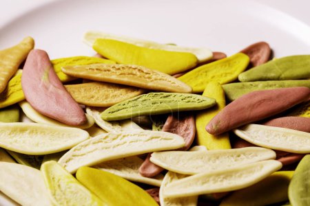 Foto de Un primer plano de pasta de hojas de olivo secas de colores en un plato blanco - Imagen libre de derechos