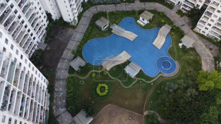 Téléchargez les photos : Une vue aérienne d'une piscine dans la cour entourée d'immeubles d'appartements élevés - en image libre de droit