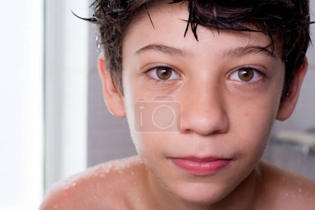Téléchargez les photos : Un gros plan d'un garçon heureux profitant de son bain - en image libre de droit