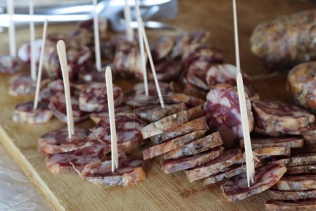 Foto de Un primer plano de una tabla de cortar de salami de cerdo negro en rodajas Nebrodi - Imagen libre de derechos