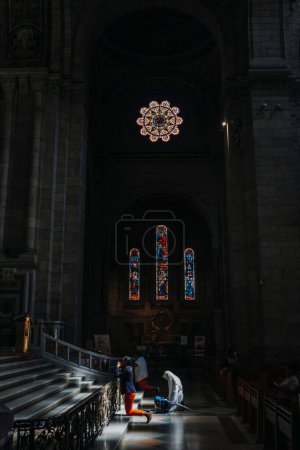 Téléchargez les photos : Plan vertical de l'intérieur d'une église avec de la lumière sur un croyant - en image libre de droit