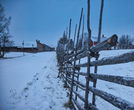Téléchargez les photos : Un gros plan de clôtures en bois dans un champ enneigé - en image libre de droit