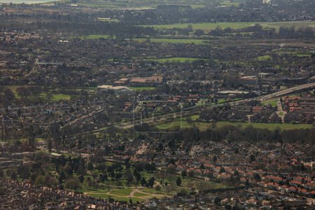 Téléchargez les photos : Vue aérienne des champs verts, des bâtiments et des routes pendant la journée du point de vue d'un avion - en image libre de droit