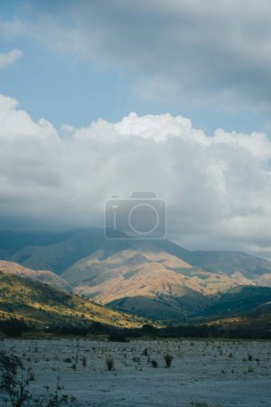 Foto de Un disparo vertical de una tierra de arena seca con la montaña bajo el cielo azul nublado en Botolan, Filipinas - Imagen libre de derechos
