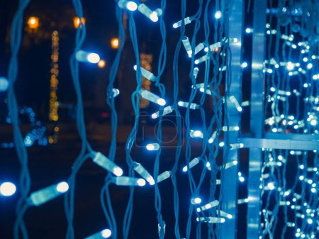 Foto de Un primer plano de luces azules de Navidad decorando e iluminando el área oscura - Imagen libre de derechos