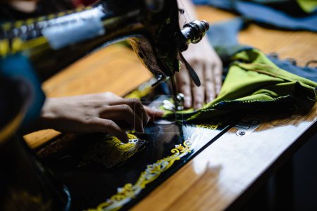 Foto de Un primer plano de una máquina de coser manual con costuras de manos a medida - Imagen libre de derechos