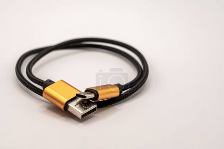 Foto de Cierre detallado de un cable USB trenzado negro con conectores de color dorado - Imagen libre de derechos