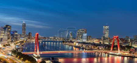 Photo for The skyline of Rotterdam at night over the river Maas showing the Willems bridge and the Erasmus bridge - Royalty Free Image