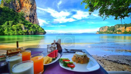 Téléchargez les photos : Un plan horizontal d'un petit déjeuner krabi avec des fruits et du jus de fruits de la plage Railay Bay Resort avec vue sur la mer - en image libre de droit