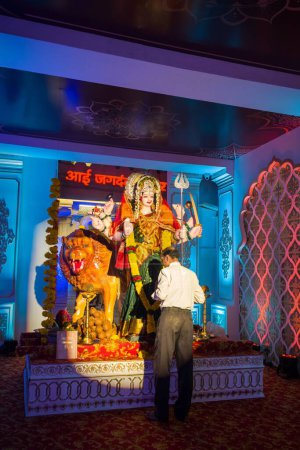 Téléchargez les photos : Un homme priant devant une idole de Maa Durga lors d'un Mandal à Mumbai pour la fête indienne de Navratri - en image libre de droit