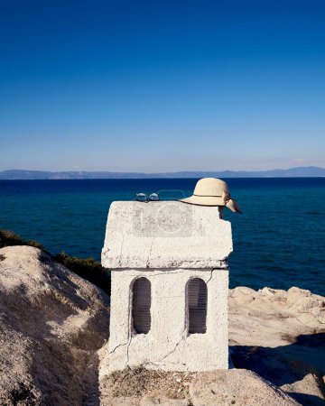 Foto de Un plano vertical de la iglesia Agios Nikolaos con el mar y un cielo azul en el fondo, Grecia - Imagen libre de derechos