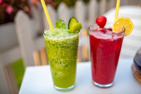 Photo for A closeup shot of two glasses of colorful mint cucumber and berries nonalcoholic lemonades - Royalty Free Image