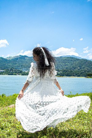 Foto de Una vista posterior de la mujer de Sri Lanka posando en vestido blanco al aire libre - Imagen libre de derechos