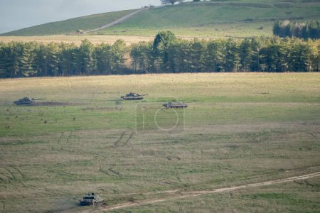 Foto de Los tanques militares se mueven en un campo - Imagen libre de derechos