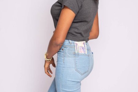 Foto de Señora africana con dinero en efectivo de menta en su bolsillo trasero - Imagen libre de derechos