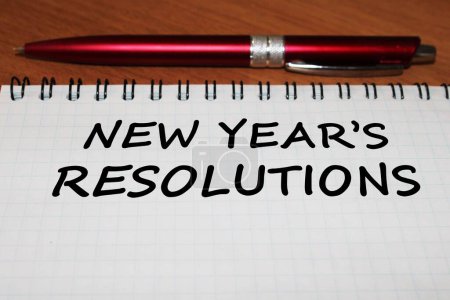 Téléchargez les photos : Gros plan d'un bloc-notes avec un stylo sur une table en bois pour les résolutions du Nouvel An - en image libre de droit