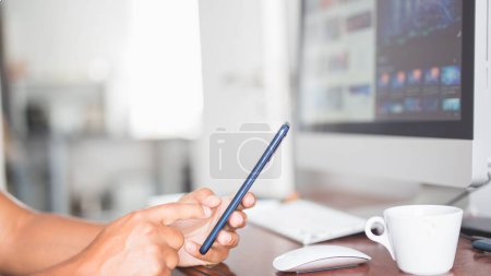 Téléchargez les photos : Gros plan d'un homme utilisant un mobile dans son bureau à domicile - en image libre de droit