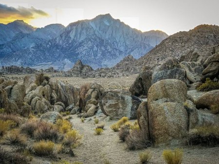 A scenic shot of the landscape of the Alabama Hills with the evening sun setting behind mountains