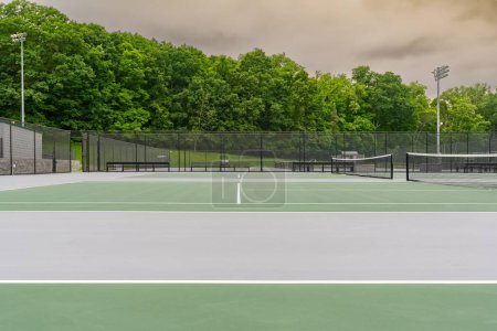 Photo for New outdoor green tennis courts with white lines. - Royalty Free Image