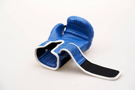 Téléchargez les photos : Un seul gant de boxe bleu avec une sangle ouverte isolée sur un fond blanc - en image libre de droit
