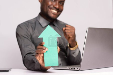 Photo for Excited african businessman holding an arrow pointing upwards - Royalty Free Image