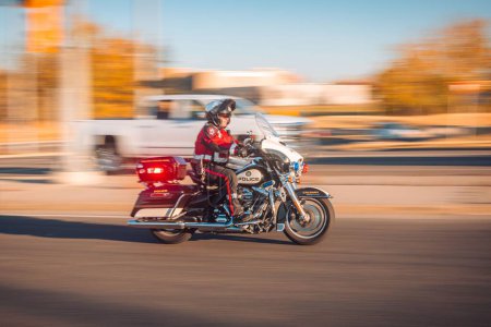Foto de Una vista borrosa del movimiento de un oficial de policía conduciendo una motocicleta con luces de emergencia activadas - Imagen libre de derechos
