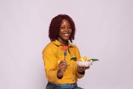 Téléchargez les photos : Dame africaine avec un bol de salade de fruits - en image libre de droit