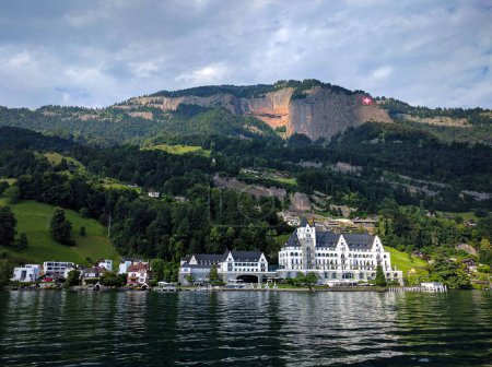 Foto de Un hermoso plano de edificios en la orilla de un lago con un fondo de montañas boscosas - Imagen libre de derechos