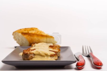 Téléchargez les photos : Bœuf cuit avec sauce au fromage isolé sur fond blanc avec couverts rouges et pain - en image libre de droit