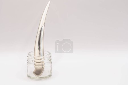 Téléchargez les photos : Un brillant couteau en acier chromé ouvre-lettre debout dans un bocal en verre transparent - en image libre de droit