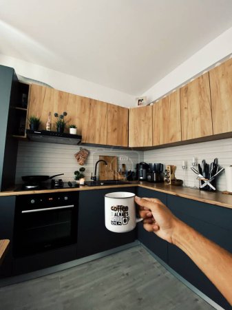 Photo for A beautiful shot of a hand of man holding a cup in a modern kitchen - Royalty Free Image