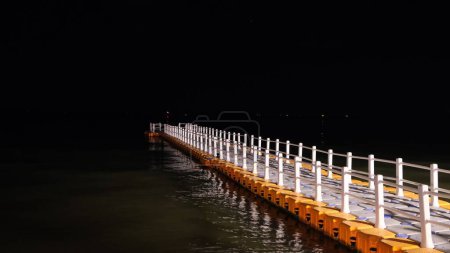 Photo for A plastic modular floating pontoon bridge over the lake at night - Royalty Free Image