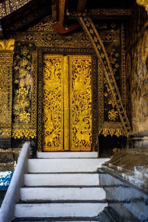 Téléchargez les photos : Un motif orné d'or sur la porte du temple bouddhiste du XVIe siècle, Wat Xieng Thong à Luang Prabang, Laos - en image libre de droit