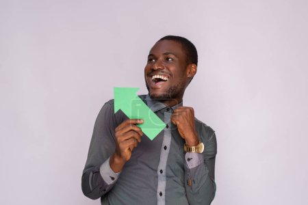 Photo for Excited black man holding and arrow pointing sideways - Royalty Free Image