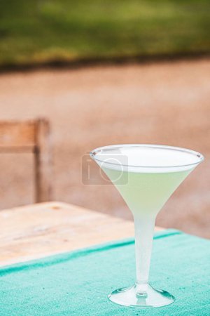 Téléchargez les photos : Plan vertical d'un verre à cocktail en plastique sur une table au fond flou - en image libre de droit