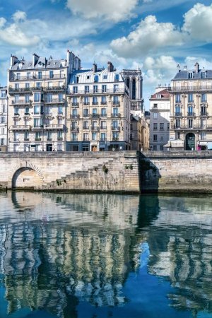 Photo for Paris, ile saint-louis and quai aux Fleurs, ancient buildings, with reflection on the Seine in summer, the Notre-Dame cathedral in background - Royalty Free Image