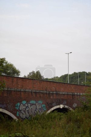 Téléchargez les photos : Plan vertical d'un pont avec graffitis et phares - en image libre de droit