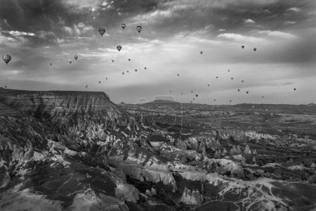 Téléchargez les photos : Une vue imprenable sur la vallée du Pasabag en Cappadoce, en Turquie, avec une belle nature, avec des montgolfières volant au-dessus de la vallée, en niveaux de gris - en image libre de droit