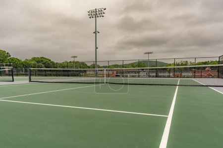 Photo for New outdoor green tennis courts with white lines. - Royalty Free Image
