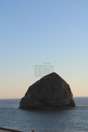 Photo for A vertical shot of giant rock formation in the sea against blue sunset sky background - Royalty Free Image