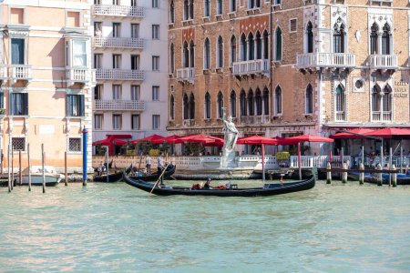Photo for A Gondola with Gondoliere in front of Hotel Bauer on the Grand canal in Venice - Royalty Free Image