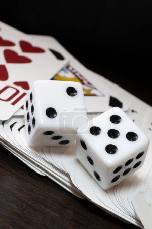 Téléchargez les photos : Un gros plan vertical de dés de jeu et de cartes à jouer sur une table en bois - en image libre de droit
