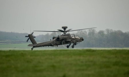 Foto de Un helicóptero de ataque gris oscuro en vuelo durante el día - Imagen libre de derechos