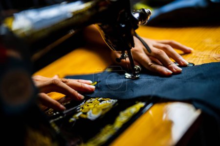 Foto de Un primer plano de una máquina de coser manual con costuras de manos a medida - Imagen libre de derechos
