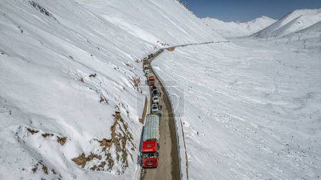 Téléchargez les photos : Un plan aérien de la route dans la neige avec des voitures de passage dans la montagne Dongda, Tibet - en image libre de droit