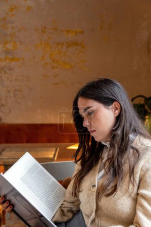 Téléchargez les photos : Une jolie femelle aux cheveux longs assise dans un café vintage - en image libre de droit